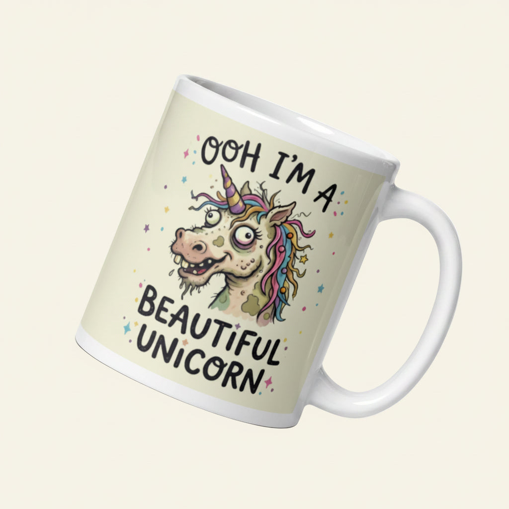 A funny, chaotic illustration on a white ceramic mug of a deranged, ugly unicorn with bloodshot eyes, crooked teeth, and messy pastel hair. The text reads OOH I'M A BEAUTIFUL UNICORN surrounded by small stars.Cucumber Dog 11 oz
