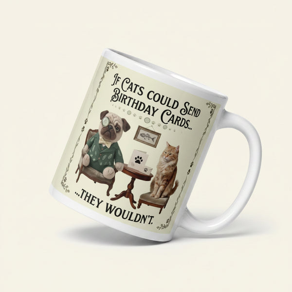 A funny graphic on a ceramic mug featuring Sir Cucumber Dog sitting next to a ginger cat and a small table. Text reads, If Cats could Send Birthday Cards... THEY WOULDN'T.