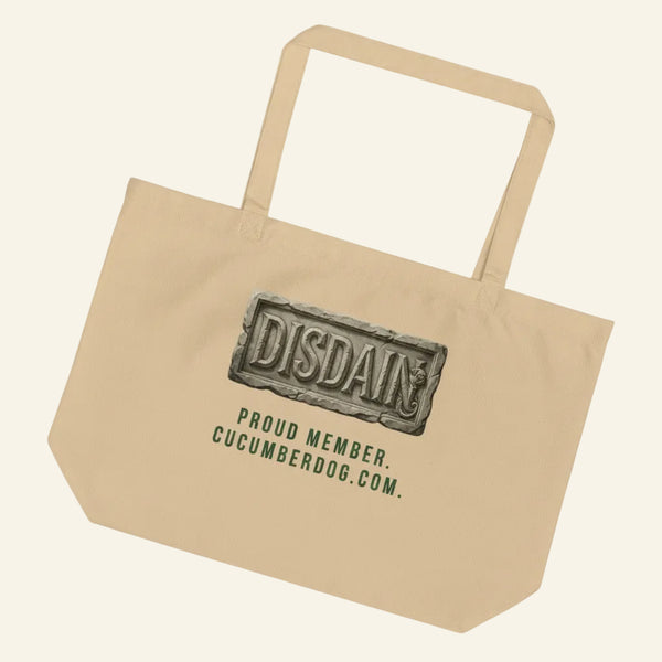 A heavy duty oyster organic cotton tote bag featuring a black rectangular print. Inside the black area is a realistic 3D stone carving of the word DISDAIN with Sir Cucumber Dog's profile hidden in the letter N. Green text below reads PROUD MEMBER CUCUMBERDOG.COM.