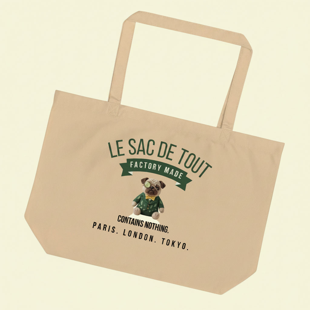 A heavy duty oyster coloured organic cotton tote bag. The front features the text LE SAC DE TOUT over a green banner reading FACTORY MADE. Below is a plush pug named Sir Cucumber Dog wearing a green suit and monocle, followed by the text CONTAINS NOTHING. PARIS. LONDON. TOKYO. The back displays the text CUCUMBERDOG.COM in green.