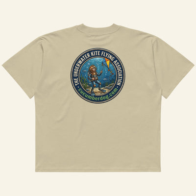 The back of a t-shirt featuring a circular nautical graphic. A vintage deep sea diver is underwater, attempting to fly a kite. The text reads The Underwater Kite Flying Association, cucumberdog.com in green lettering.
