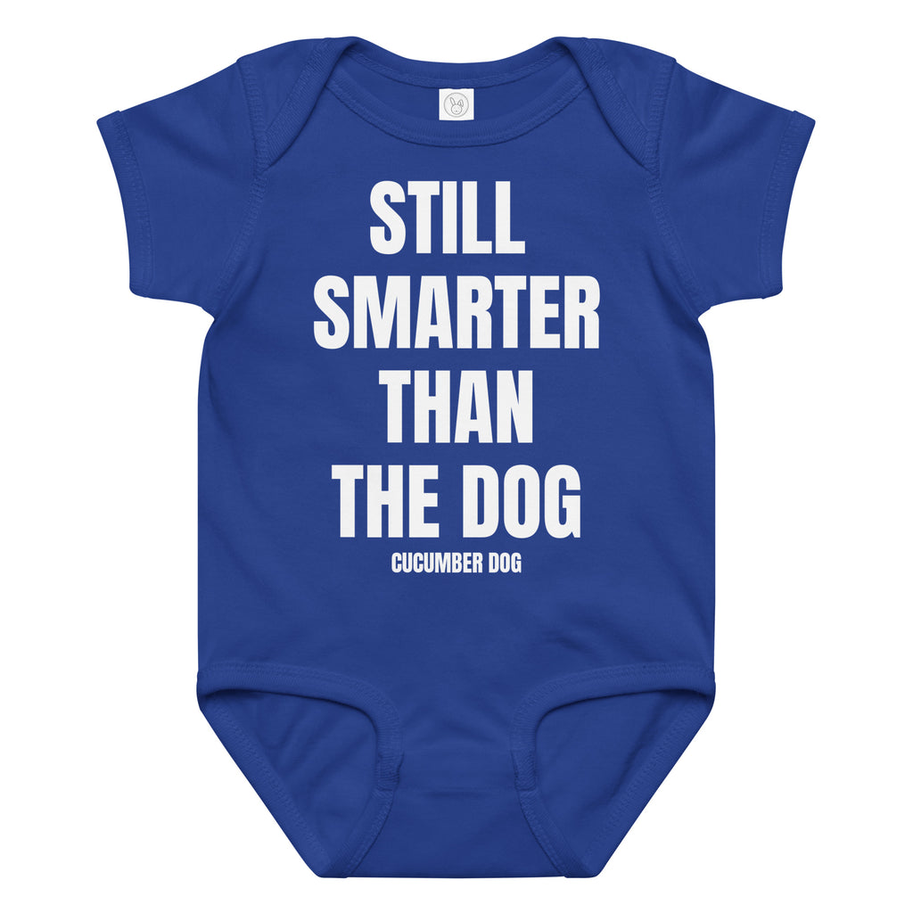 Blue baby onesie with the words still smarter than the dog. White text on a white background. Cucumber Dog