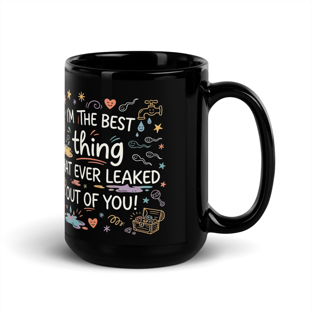 A tilted black glossy ceramic mug on a light beige background. The design features colourful hand drawn typography and doodles. The text reads I'M THE BEST thing THAT EVER LEAKED OUT OF YOU! in white and teal script. The surrounding icons include white sperm cells, a dripping golden tap, hearts, stars, a treasure chest, and a baby rattle in pastel colours.