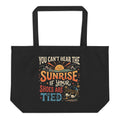 A large black eco tote bag featuring a retro 1970s design of a smiling sun and mountains with the funny, nonsensical quote You Can Not Hear The Sunrise If Your Shoes Are Tied.