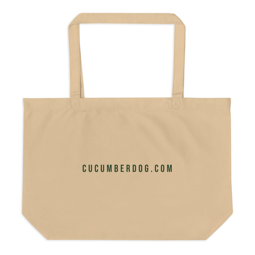 A heavy duty oyster coloured organic cotton tote bag. The front features the text LE SAC DE TOUT over a green banner reading FACTORY MADE. Below is a plush pug named Sir Cucumber Dog wearing a green suit and monocle, followed by the text CONTAINS NOTHING. PARIS. LONDON. TOKYO. The back displays the text CUCUMBERDOG.COM in green.