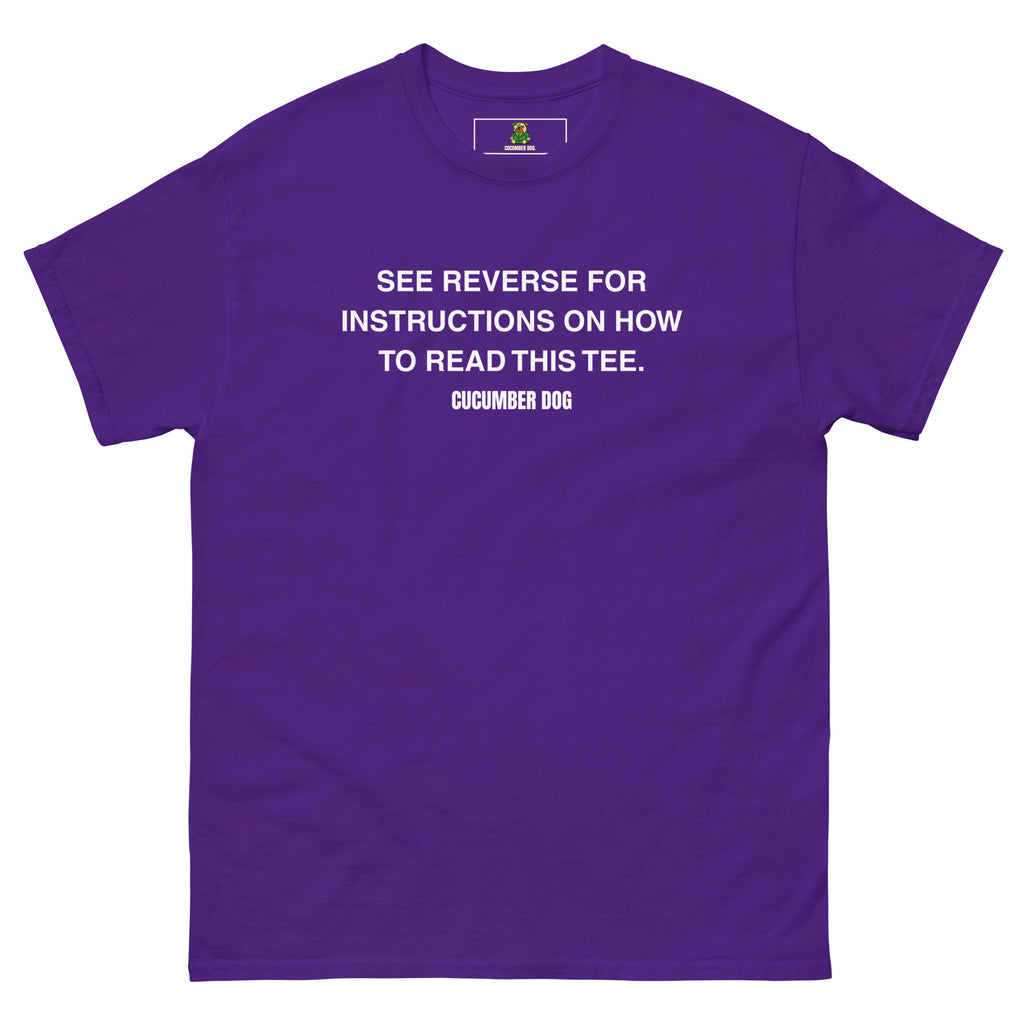 Purple t-shirt with the words see reverse for instructions on how to read this tee. White text on a white background. Cucumber Dog