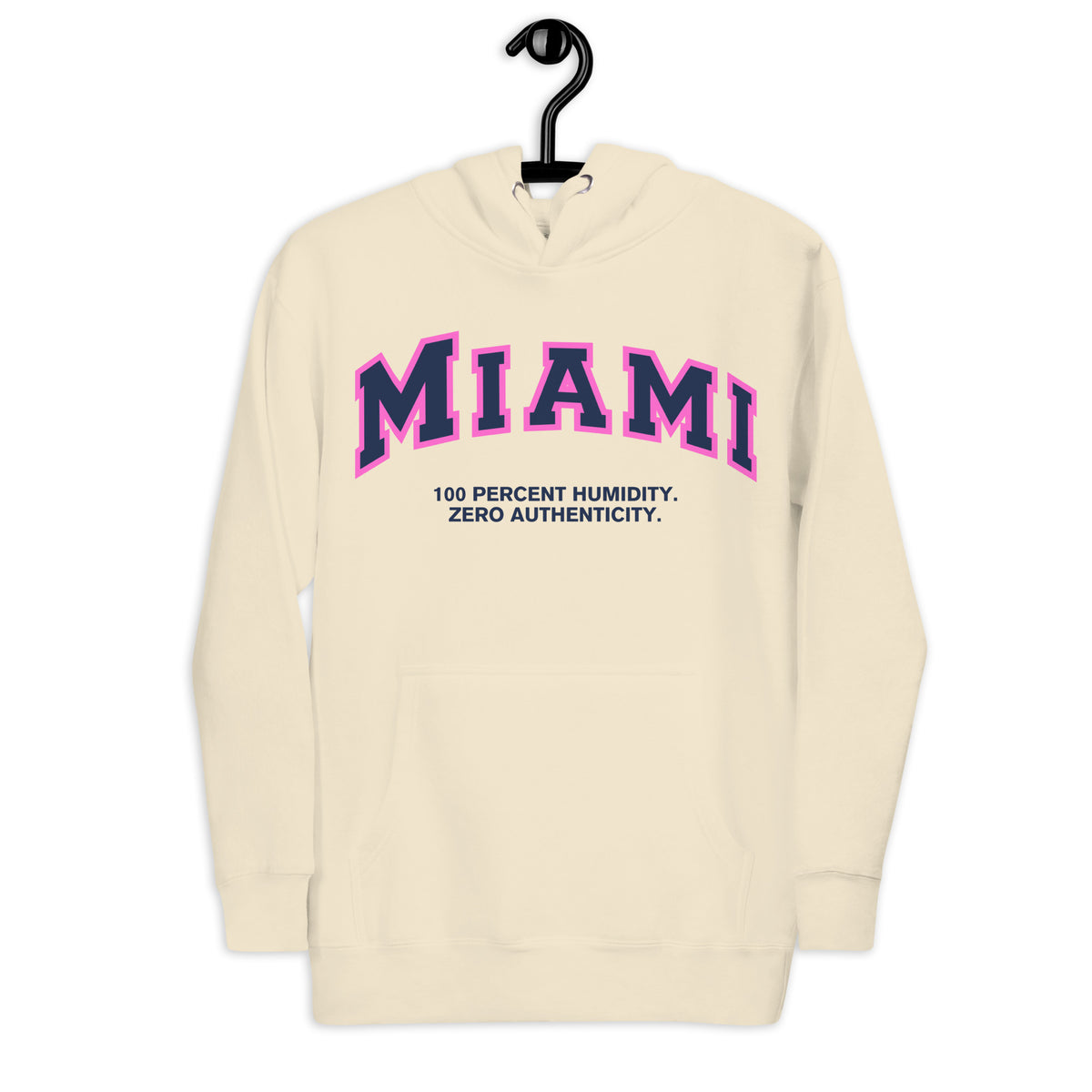 Premium bone coloured hoodie featuring a vintage athletic graphic with arched Miami text in dark blue and pink, and the phrase 100 Percent Humidity Zero Authenticity printed underneath in a solid black serif font.