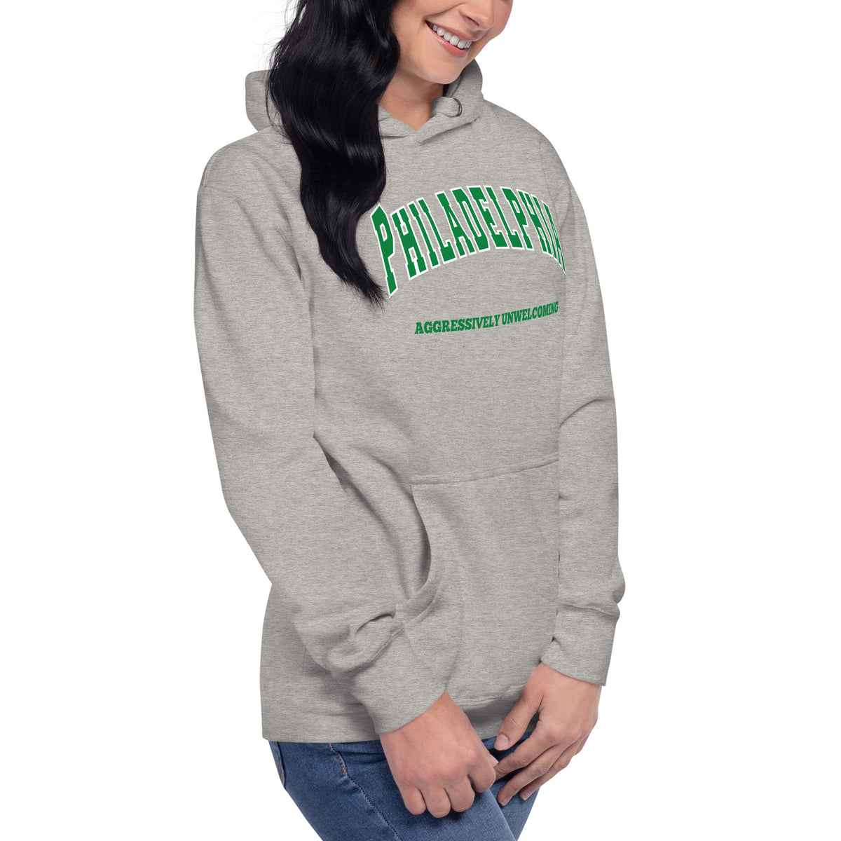 Premium carbon grey hoodie featuring a vintage athletic graphic with arched Philadelphia text in green and white, and the phrase Aggressively Unwelcoming printed underneath in a solid green serif font.