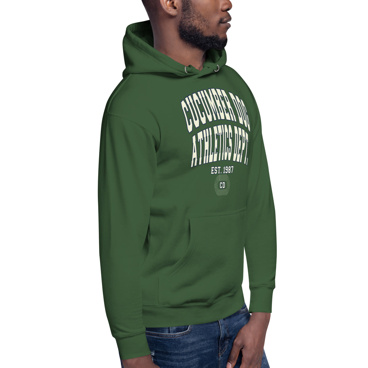 Premium forest green hoodie featuring a vintage athletic graphic with arched Cucumber Dog and Athletics Dept text in solid cream with a navy outline block typography, above Est. 1987 and a track motif framing the CD monogram.