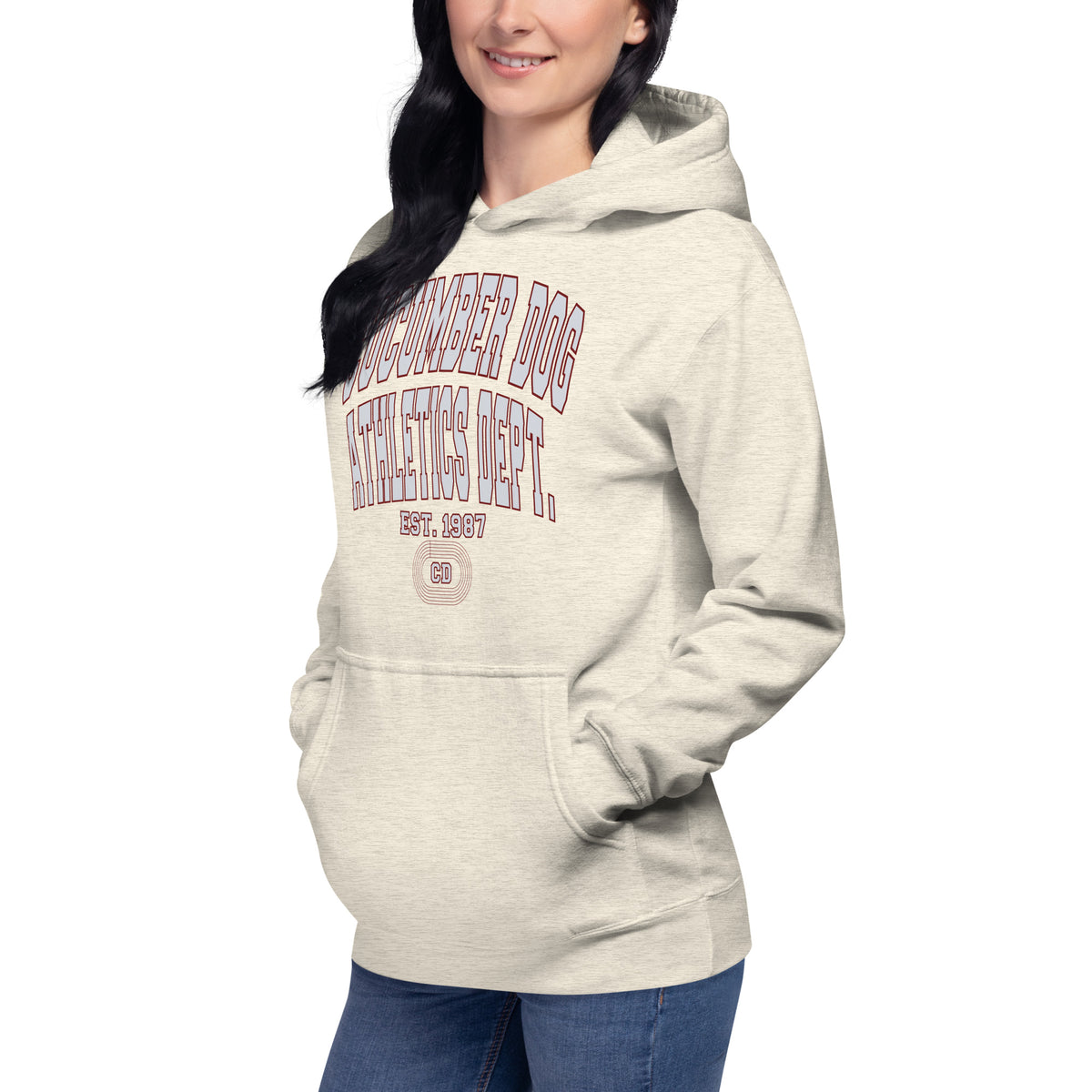 Premium oatmeal heather hoodie featuring a vintage athletic graphic with arched Cucumber Dog and Athletics Dept text in grey block typography with a maroon outline, above Est. 1987 and a track motif framing the CD monogram.