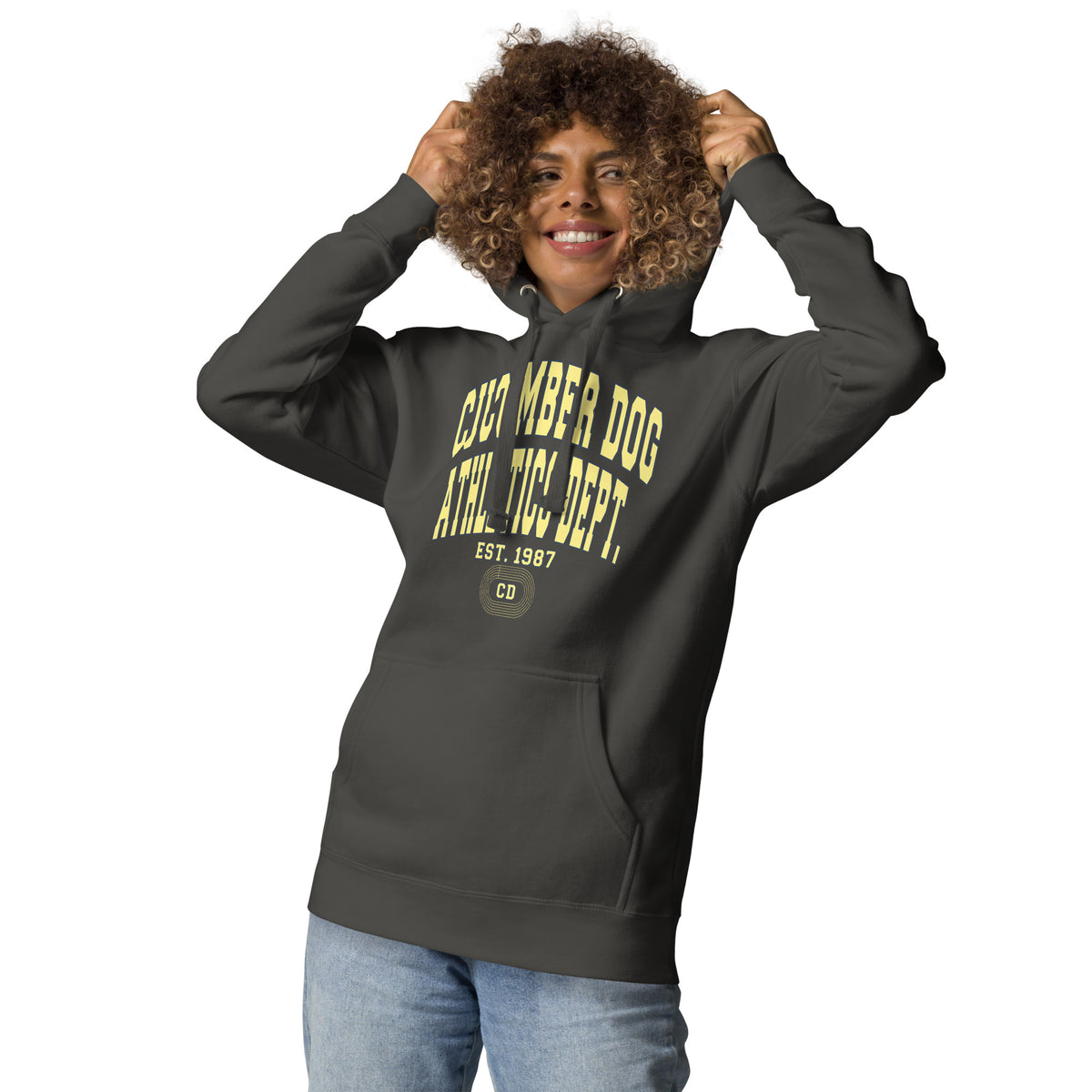 Premium vintage black hoodie featuring a vintage athletic graphic with arched Cucumber Dog and Athletics Dept text in solid butter cream block typography, above Est. 1987 and a track motif framing the CD monogram.