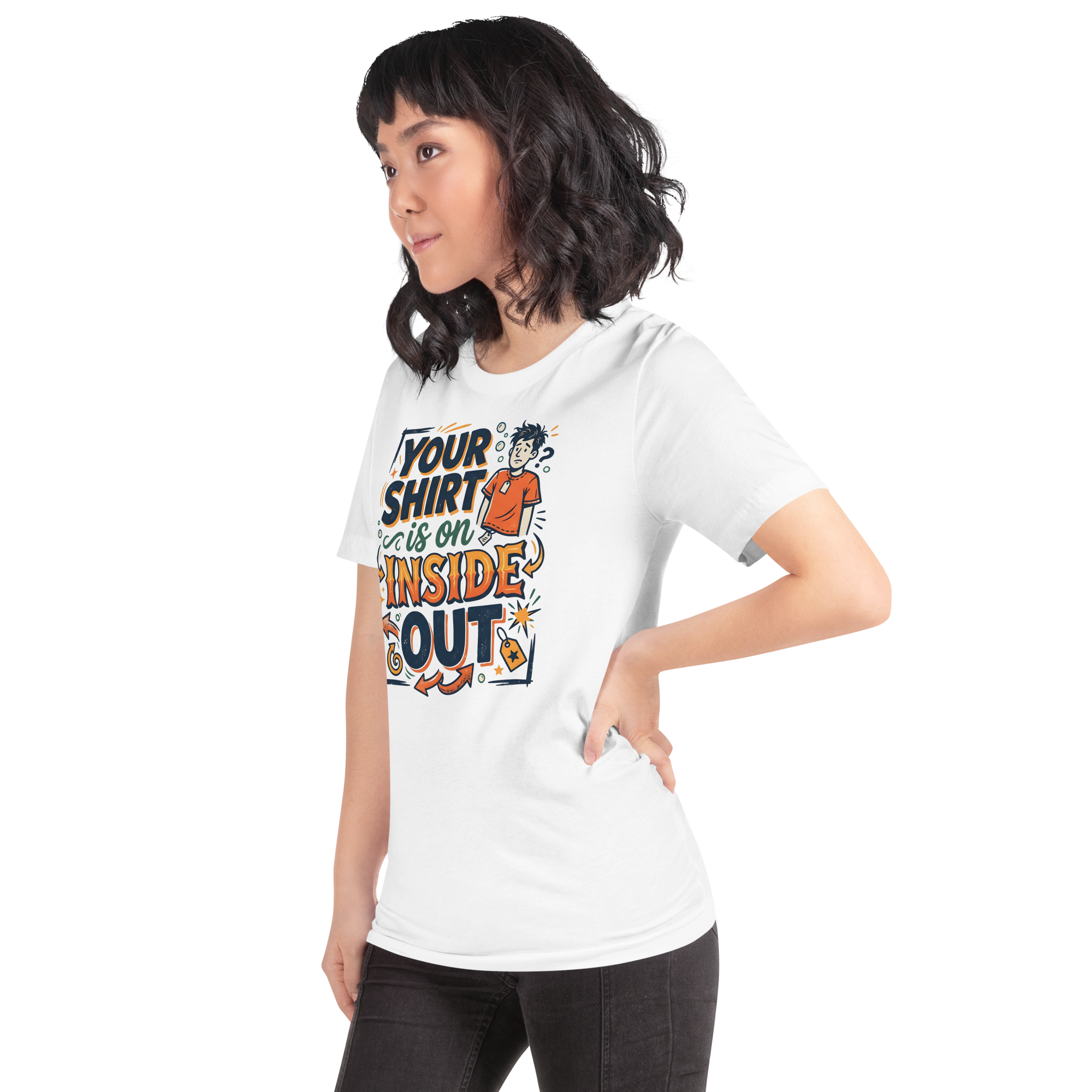 Person wearing a white unisex t-shirt featuring a cartoon illustration of a confused man with an exposed clothing tag, surrounded by bold retro typography that reads: YOUR SHIRT IS ON INSIDE OUT.