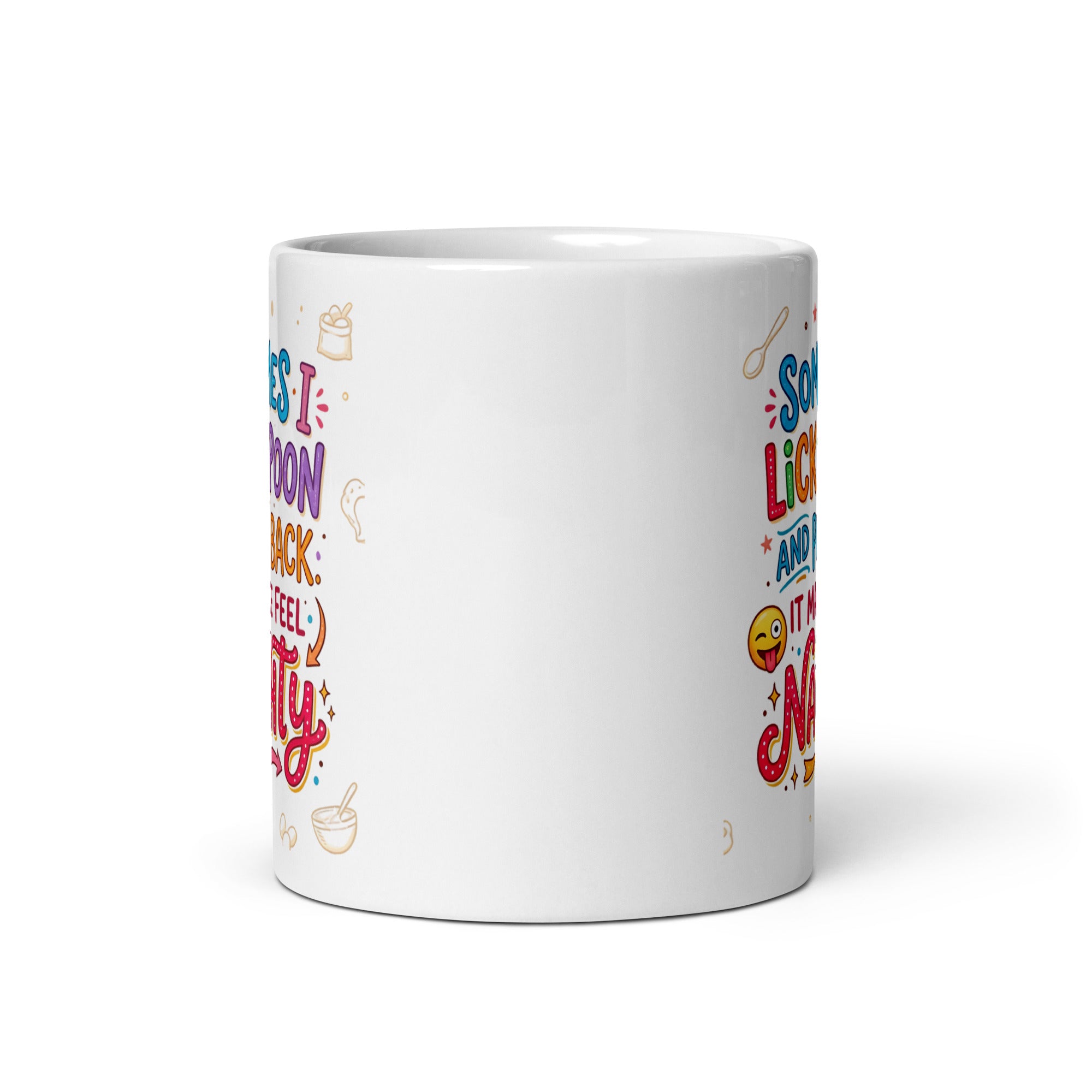 A white ceramic mug featuring playful and colourful typography in blue, pink, orange, and purple. The text reads SOMETIMES I LICK THE SPOON AND PUT IT BACK IT MAKES ME FEEL NAUGHTY. The design is decorated with small hand drawn icons of spoons, stars, a bag of flour, and a winking emoji with its tongue sticking out.