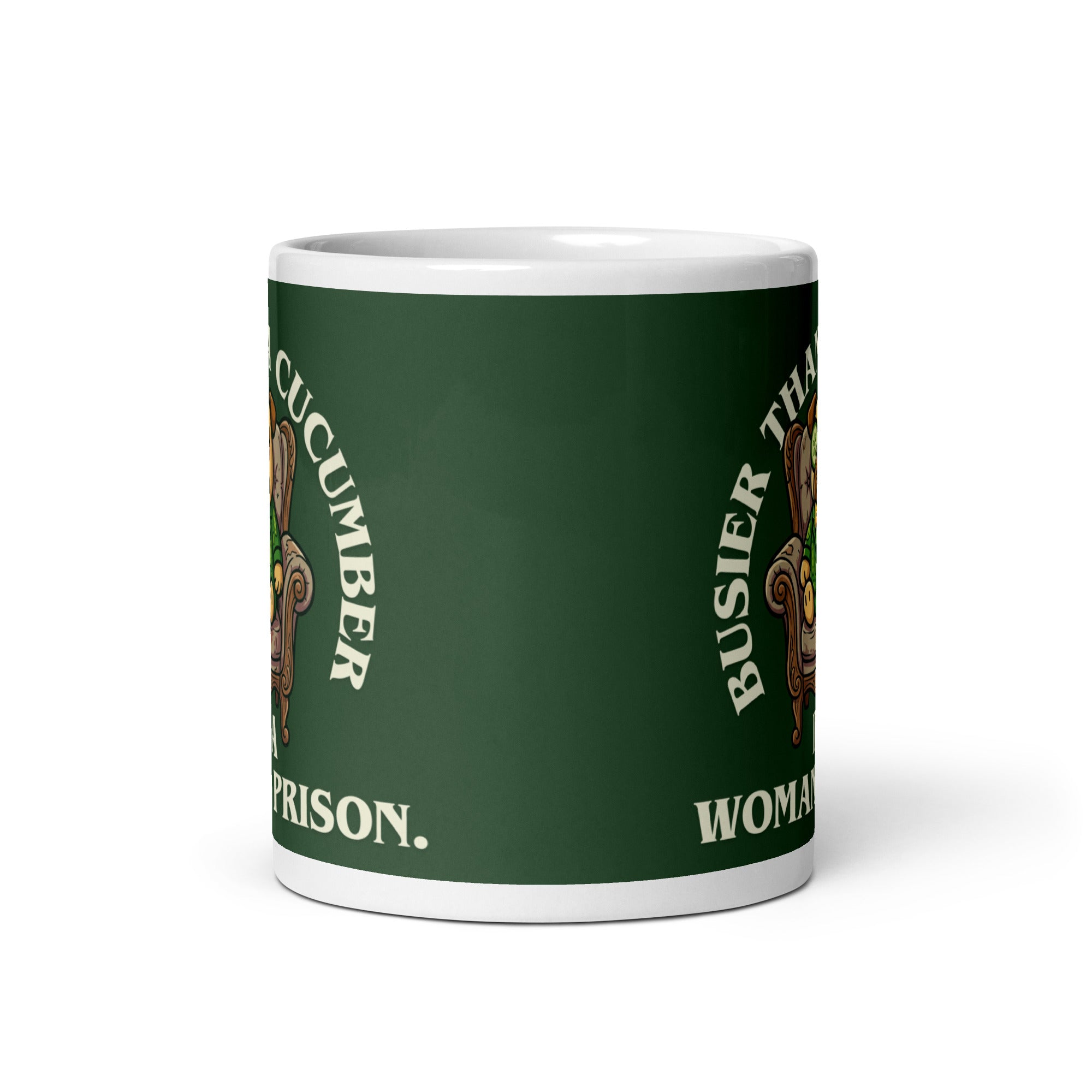 A tilted white ceramic mug with a large dark green label. In the centre of the label, a pug named Sir Cucumber Dog sits in an armchair wearing a cucumber suit and monocle. The white text reads BUSIER THAN A CUCUMBER IN A WOMAN S PRISON.