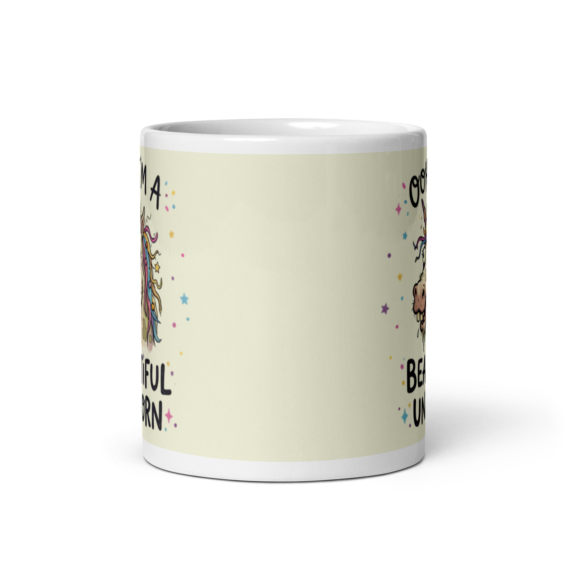 A funny, chaotic illustration on a white ceramic mug of a deranged, ugly unicorn with bloodshot eyes, crooked teeth, and messy pastel hair. The text reads OOH I'M A BEAUTIFUL UNICORN surrounded by small stars.