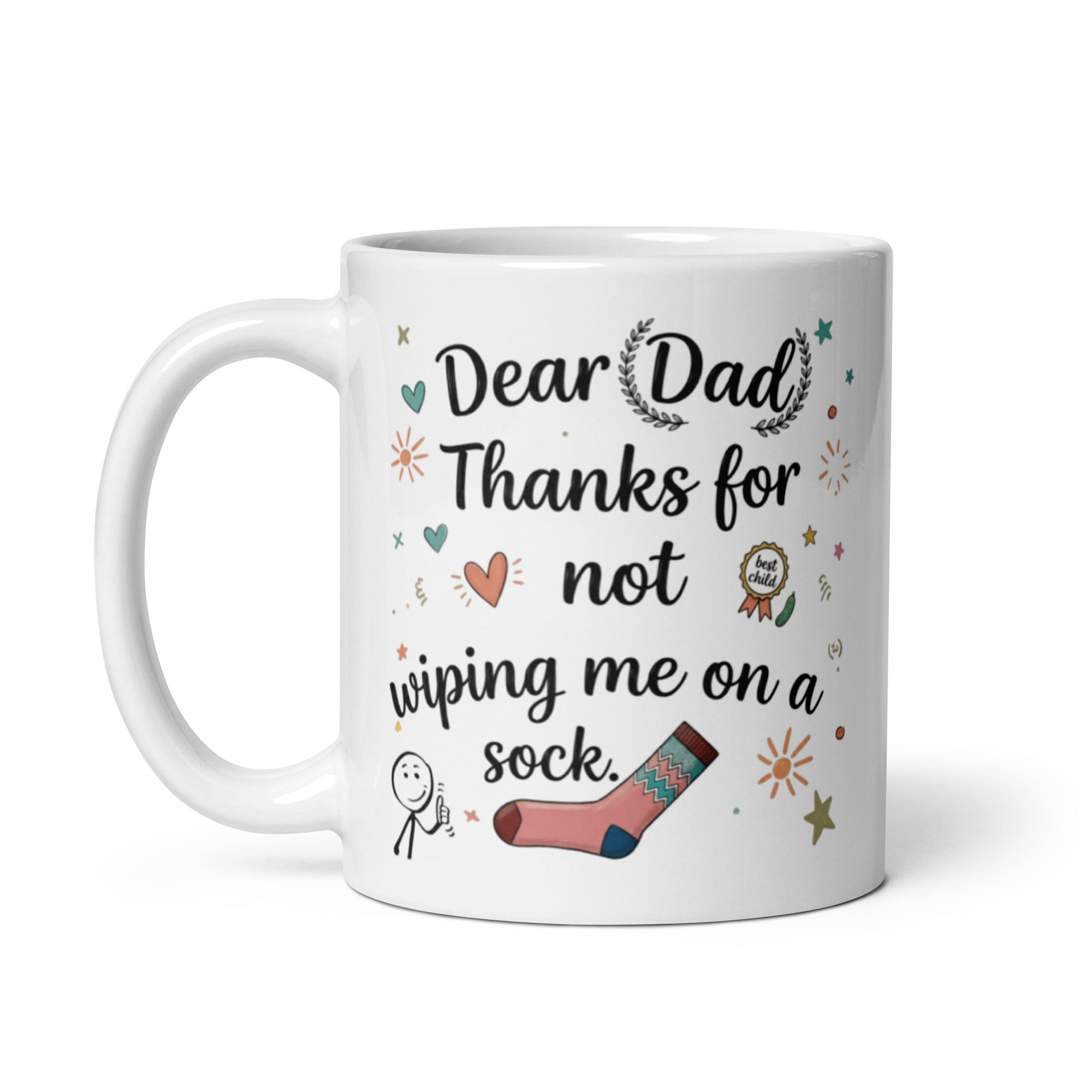 A white ceramic mug on a white surface. The design features playful, hand drawn style text that reads DEAR DAD THANKS FOR NOT WIPING ME ON A SOCK. The typography is surrounded by whimsical icons including a pink patterned sock, a smiling stick figure, a gold best child medal, and small sun and heart illustrations.
