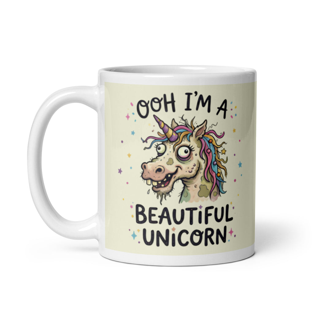 A funny, chaotic illustration on a white ceramic mug of a deranged, ugly unicorn with bloodshot eyes, crooked teeth, and messy pastel hair. The text reads OOH I'M A BEAUTIFUL UNICORN surrounded by small stars.