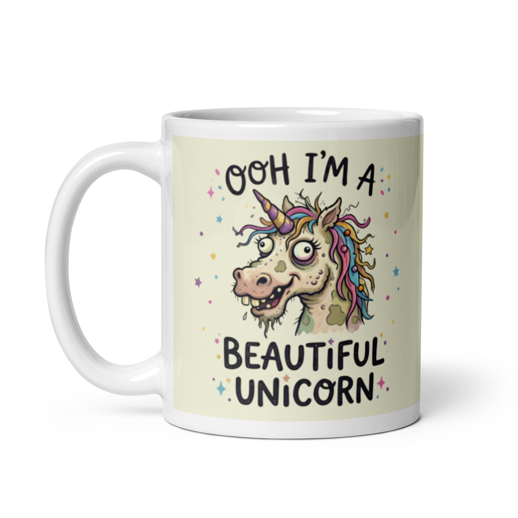 A funny, chaotic illustration on a white ceramic mug of a deranged, ugly unicorn with bloodshot eyes, crooked teeth, and messy pastel hair. The text reads OOH I'M A BEAUTIFUL UNICORN surrounded by small stars.